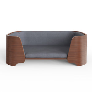 Jual Furnishings luxury pet bed featuring a curved walnut wood frame with a smooth finish, complemented by plush gray fabric cushioning, designed for comfort and modern style, set against a white background